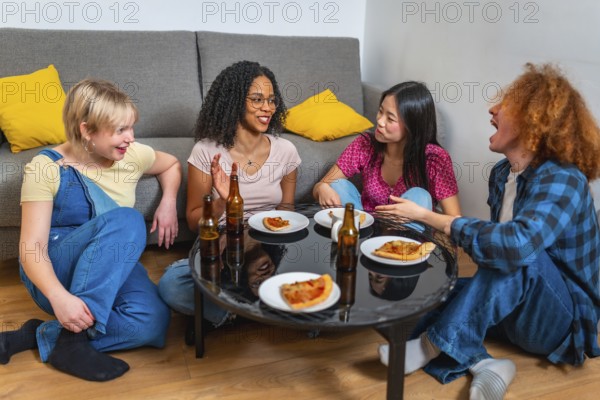 Four diverse friends sitting around a table, laughing and talking while enjoying pizza and drinks