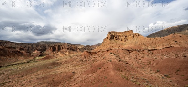 Eroded mountain landscape with sandstone cliffs, red and orange rock formations, Konorchek Canyon,