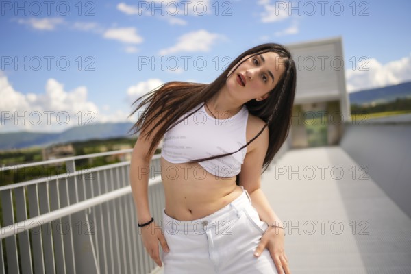 Caucasian young sportive woman moving sensually looking at camera while performing urban dance on