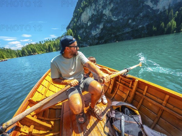 Tourists enjoying a sunny day rowing on the famous lake braies, surrounded by the stunning