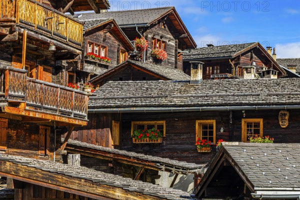 Old wooden houses decorated with flowers in the historic village centre, Grimentz, Val d'Anniviers,