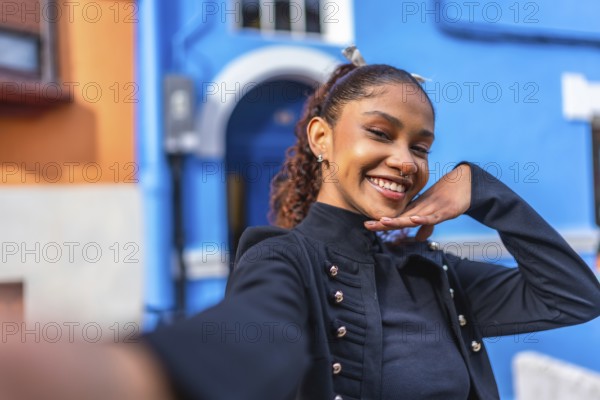 Beauty flirty african american woman gesturing hand down chin smiling while taking a selfie in a