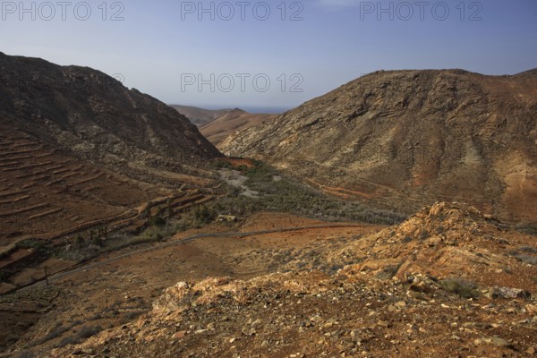 Rough, barren valley between steep mountains near the village of Vega de Rio Palmas under sunny