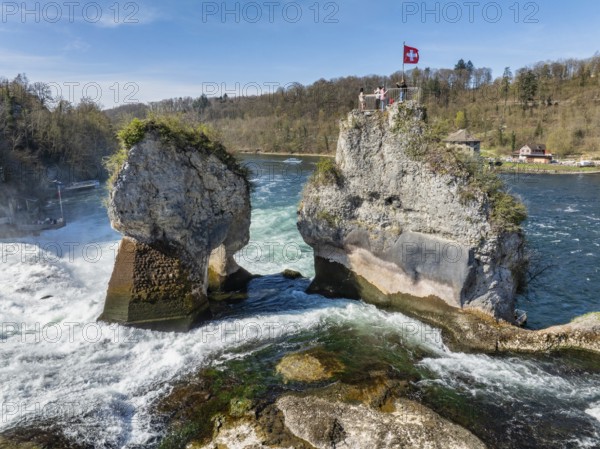 Aerial view of the Rhine Falls at low water in spring, with tourists on the viewing platform,