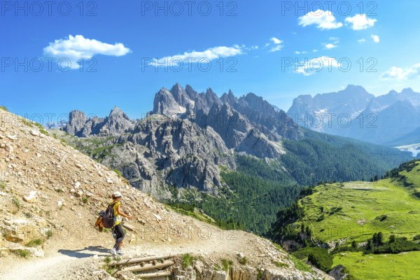 Female tourist hiking on a mountain trail with breathtaking views of the tre cime di lavaredo peaks
