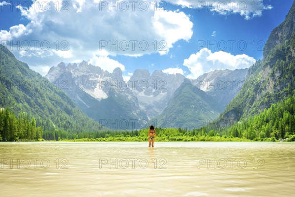 Woman standing in the water enjoying a summer swim in the beautiful lago di landro with the
