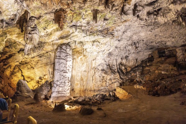 Tourists riding a train admiring the illuminated stalagmites and stalactites inside the famous