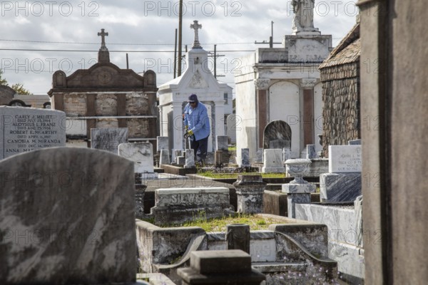 New Orleans, Louisiana - A groundskeeper at work in St. Joseph Cemetery #1, established in 1854.