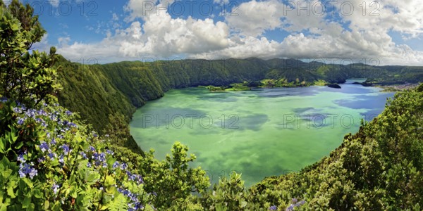 Breathtaking panoramic view of the crater lake Lagoa Azul surrounded by steep rock faces under a