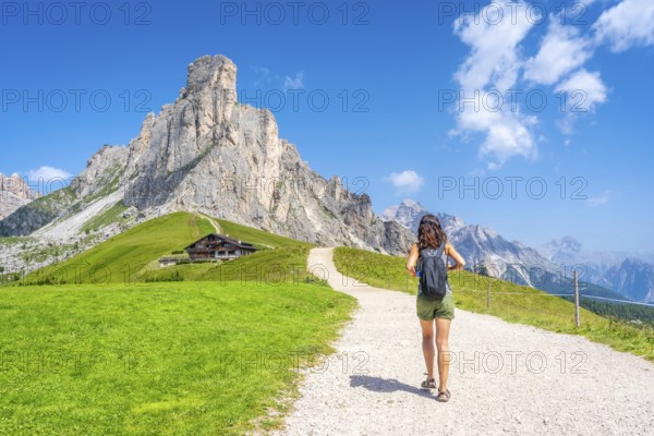 Female tourist walking on a path enjoying the scenic landscape of the giau pass in the dolomites,