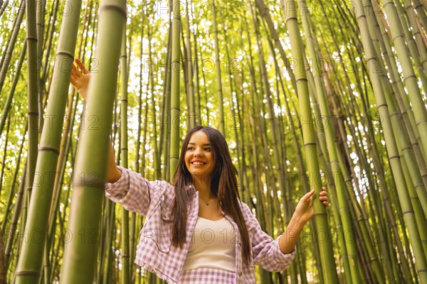 Young caucasian girl with a pink skirt in a bamboo forest. Enjoying summer holidays in a tropical