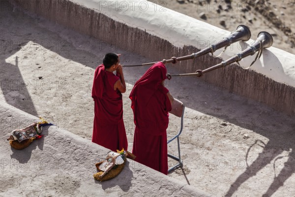 THIKSEY, INDIA, SEPTEMBER 4, 2011: Two Tibetan Buddhist monks blowing Tibetan horn (dungche) during