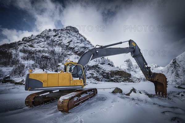 Old excavator with excavator bucket in winter. Road construction in snow. Lofoten islands, Norway,