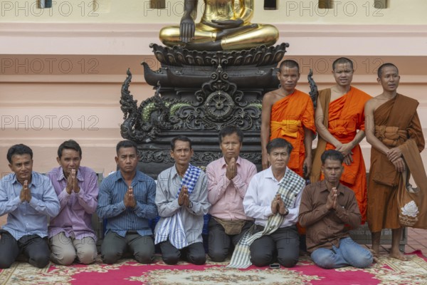 Monks and Laotians in front of a Buddha statue, Bhumispara-mudra, Buddha Gautama at the moment of