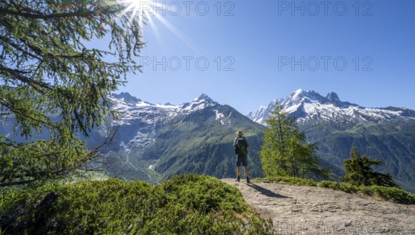 Mountaineer on hiking trail, mountain panorama with glaciated mountain peaks, Aiguille Verte, hike