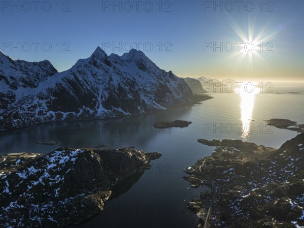 Aerial view of fjord and steep mountains, coast, winter, evening light, sun rays, Vestvagoya,