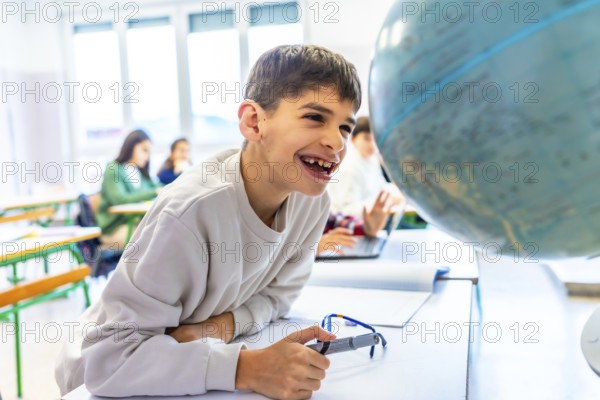 Happy student with down syndrome smiling while exploring a globe in geography class, showcasing