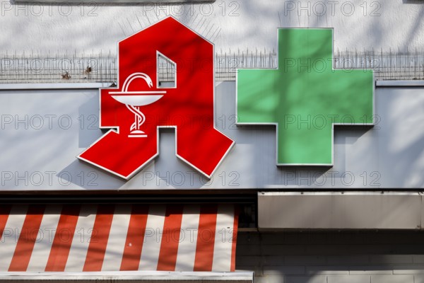 Pharmacies are systemically relevant in the corona crisis, red logo and green cross on the facade