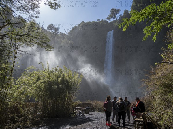 Tourists in front of waterfall Salto El Leon, valley of waterfalls east of Pucon, La Auracania,