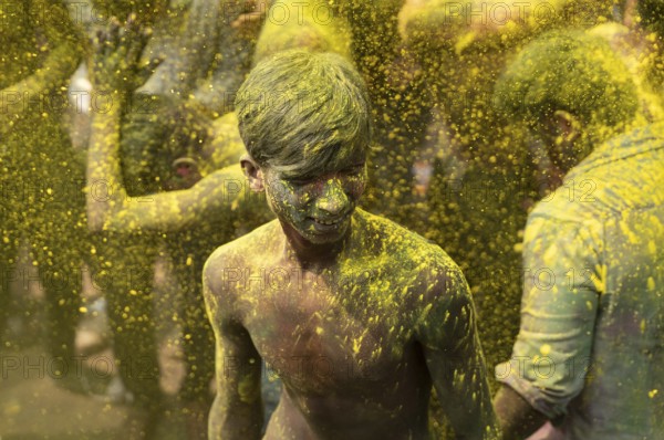 Revellers dancing in the beat of music as they celebrate Holi on a street, the Hindu spring