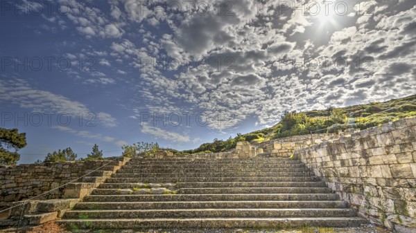 Stone staircase in an ancient ruin under a sunny sky with clouds, historical site, Kamiros,