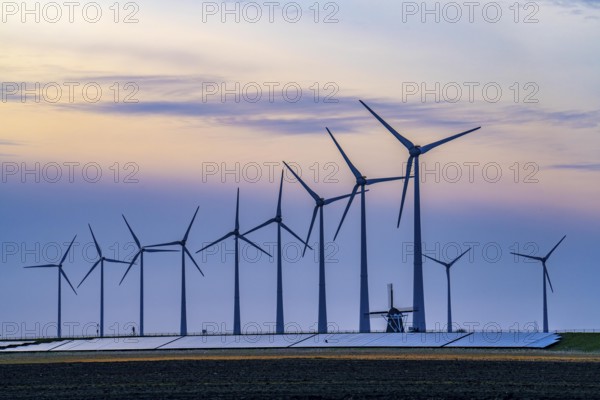 Windmill Poldermolen De Goliath stands between the high-tech wind turbines in Eemshaven, historic