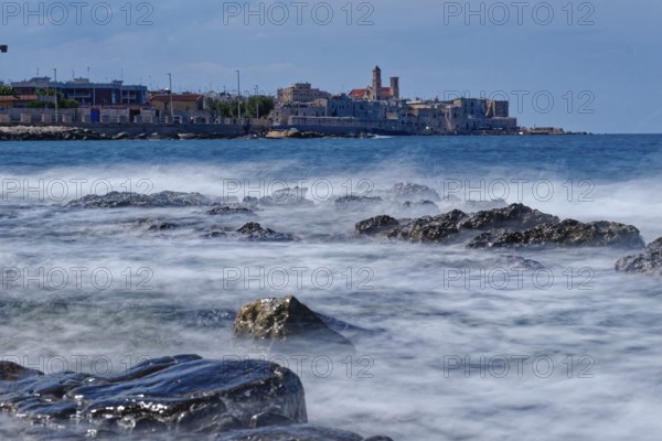 Rocky beach and gentle waves in the Mediterranean near Giovinazzo in the province of Bari.