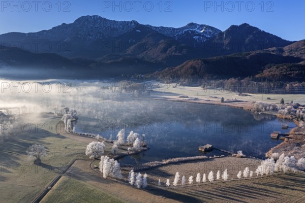 Aerial view of a lake in front of mountains in winter, hoarfrost, morning light, view of