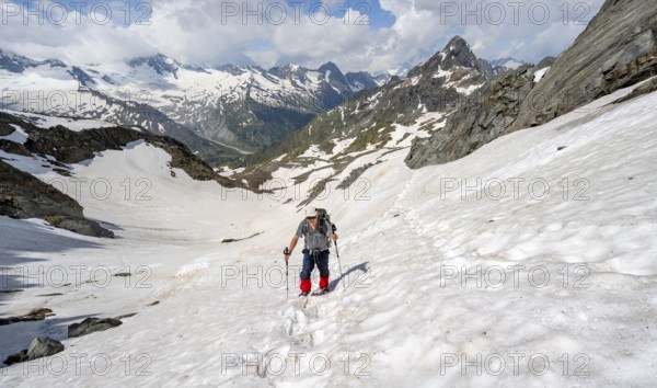 Mountaineer crossing a snowfield, ascent to the Nördliche Mörchnerscharte, mountain peak with snow