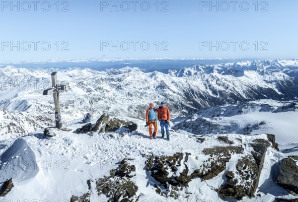 Two ski tourers on the summit of Cevedale, Alpine panorama, Aerial view, Snow-covered mountain