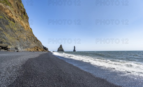 Black beach with cliffs, rock Reynisdrangar in the water, at Reynisfjara beach, Vik, South Iceland,