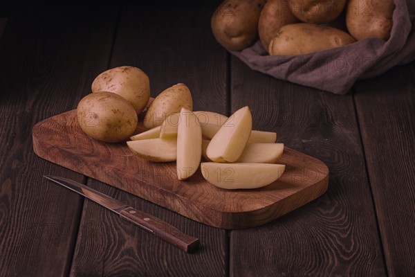 Raw potatoes, sliced, on a wooden table, top view, no people