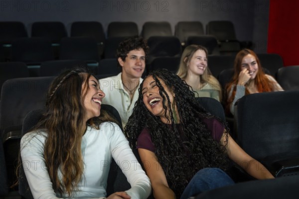 Friends enjoying laughter together while watching a comedy film at the cinema, sharing moments of