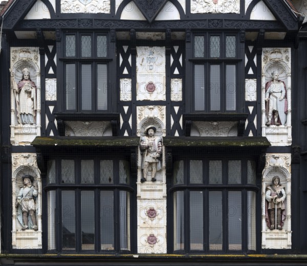 Half-timbered upper elevation painted statues, Peterborough, Cambridgeshire, England, UK designed