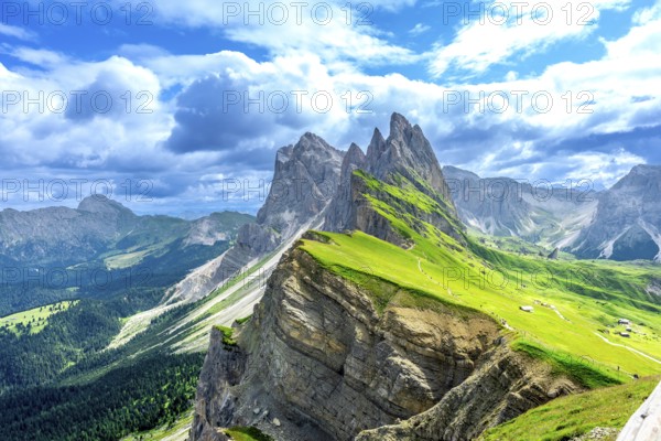 Hiking trails wind through lush green valleys beneath the majestic peaks of the seceda mountains in