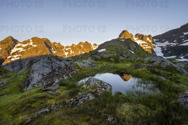 Rocky mountain peaks with reflection, small pond in moor landscape at Trollfjord Hytta, mountain