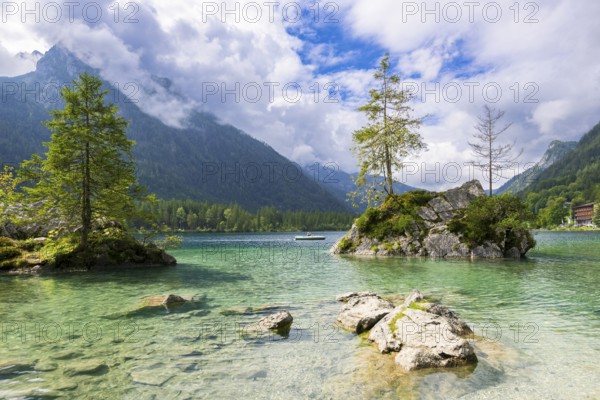 Hintersee near Ramsau with clear green water, surrounded by forests and mountains under a cloudy