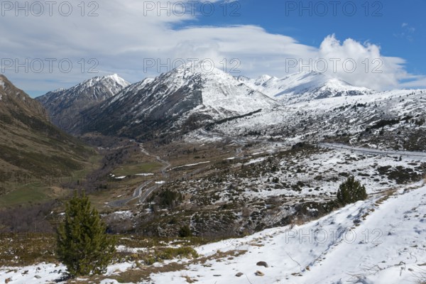Weitläufiges Tal in den Bergen, teils mit Schnee bedeckt, unter blauem Himmel, nördlich von El Pas