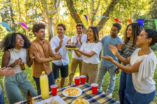 Happy young caucasian woman carrying a birthday cake while celebrating birthday in a park with