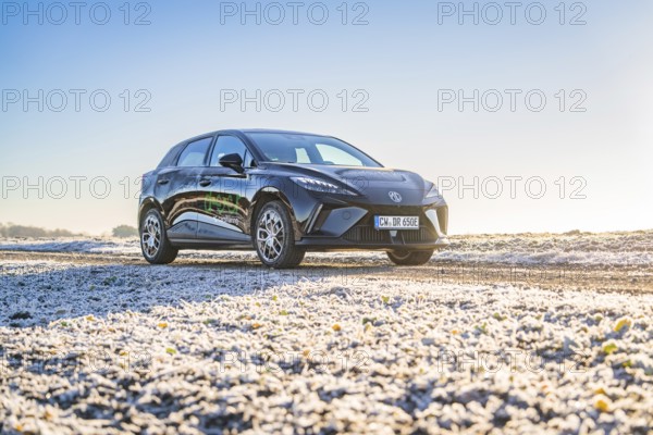 Black car on slightly icy ground under a bright morning sky, Deer E- Carsharing vehicle MG4, Calw