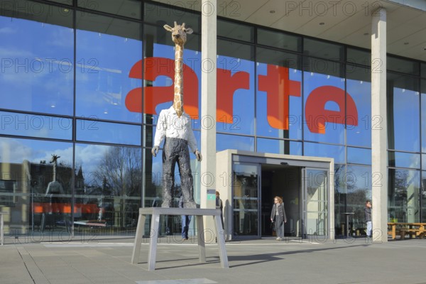 Entrance to the modern building of the ARD and ZDF broadcasting station Arte with sculpture Giraffe
