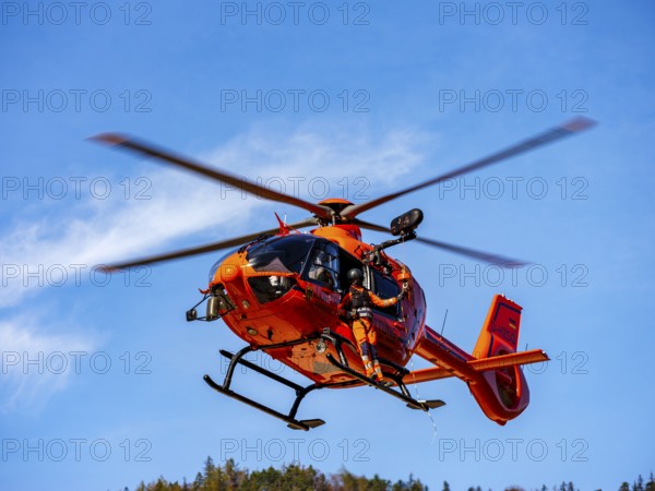 On-board mechanic of the rescue helicopter Christoph 14 winching with the cable winch, Bad