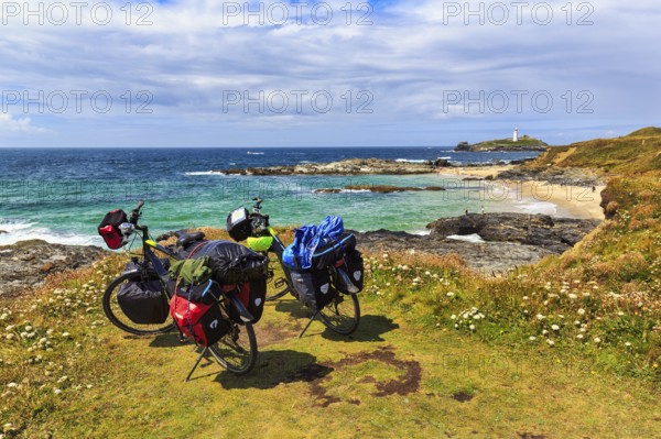 Two e-bikes on the South West Coast Path, coastline with Godrevy Island and lighthouse, landscape