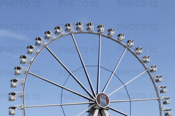 Ferris wheel with Hamburg city coat of arms against a blue sky in summer on Hamburg Cathedral,
