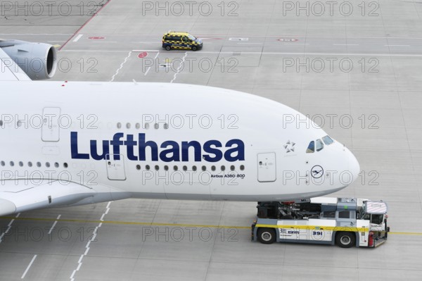 Lufthansa Airbus A380-800 being towed with push back truck on taxiway towards Lufthansa maintenance
