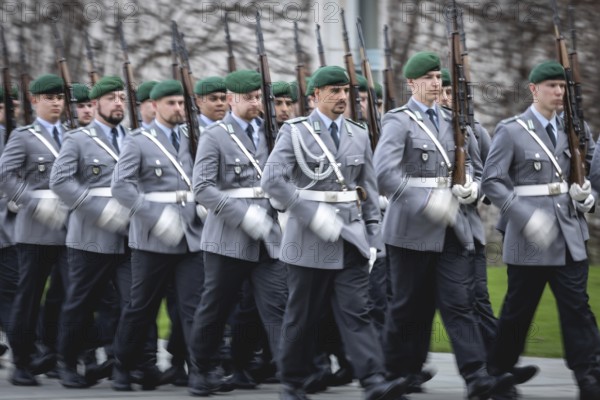 Army soldiers of the guard battalion march as part of an honour formation at the Chancellery in