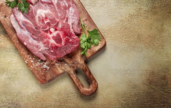 Raw steak, veal neck on the bone, fresh meat, on a cutting board, with spices, top view, without