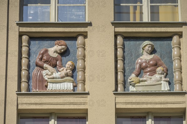 Mothers looking after their babies, relief on an old building, former woman's and children's
