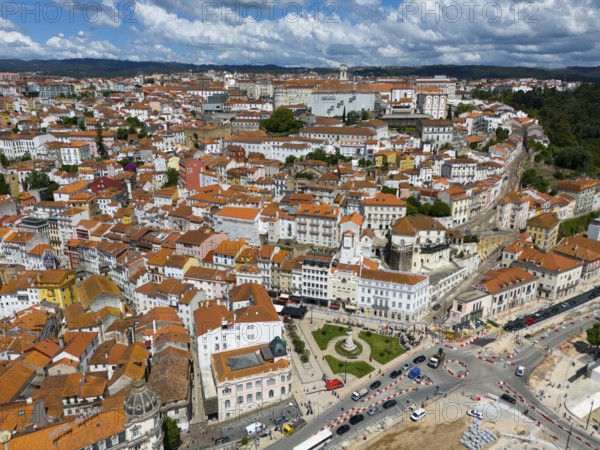 City view with red tiled roofs, densely built-up buildings and a blue sky with clouds, aerial view,
