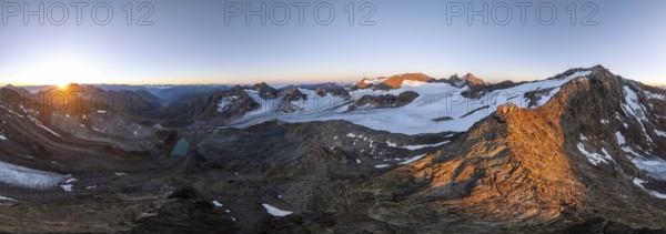 Atmospheric sunrise in a picturesque mountain landscape, alpenglow, aerial view, mountain hut